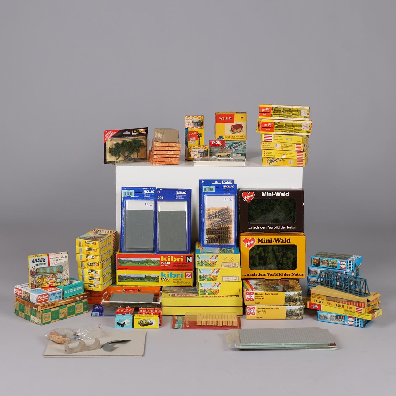 A collection of assorted model train accessories such as KIBRI, FALLER, FLEISCHMANN, HERPA, HEKI, BUSCH, JOUEF, MARKLIN, POLA, TT START, VOLLMER, ARNOLD-N, AIRFIX. (76).
