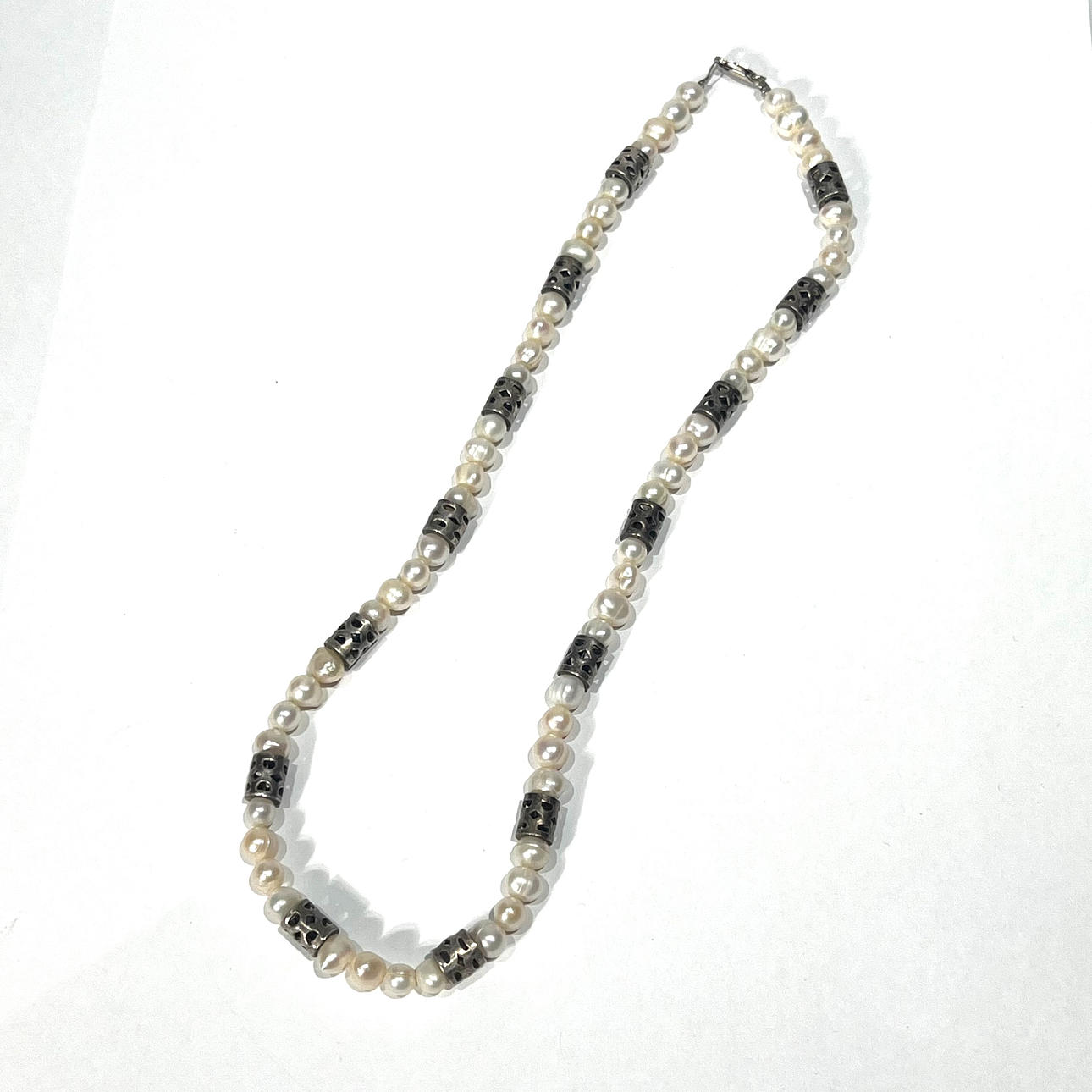 Pearl necklace with silver openwork details.