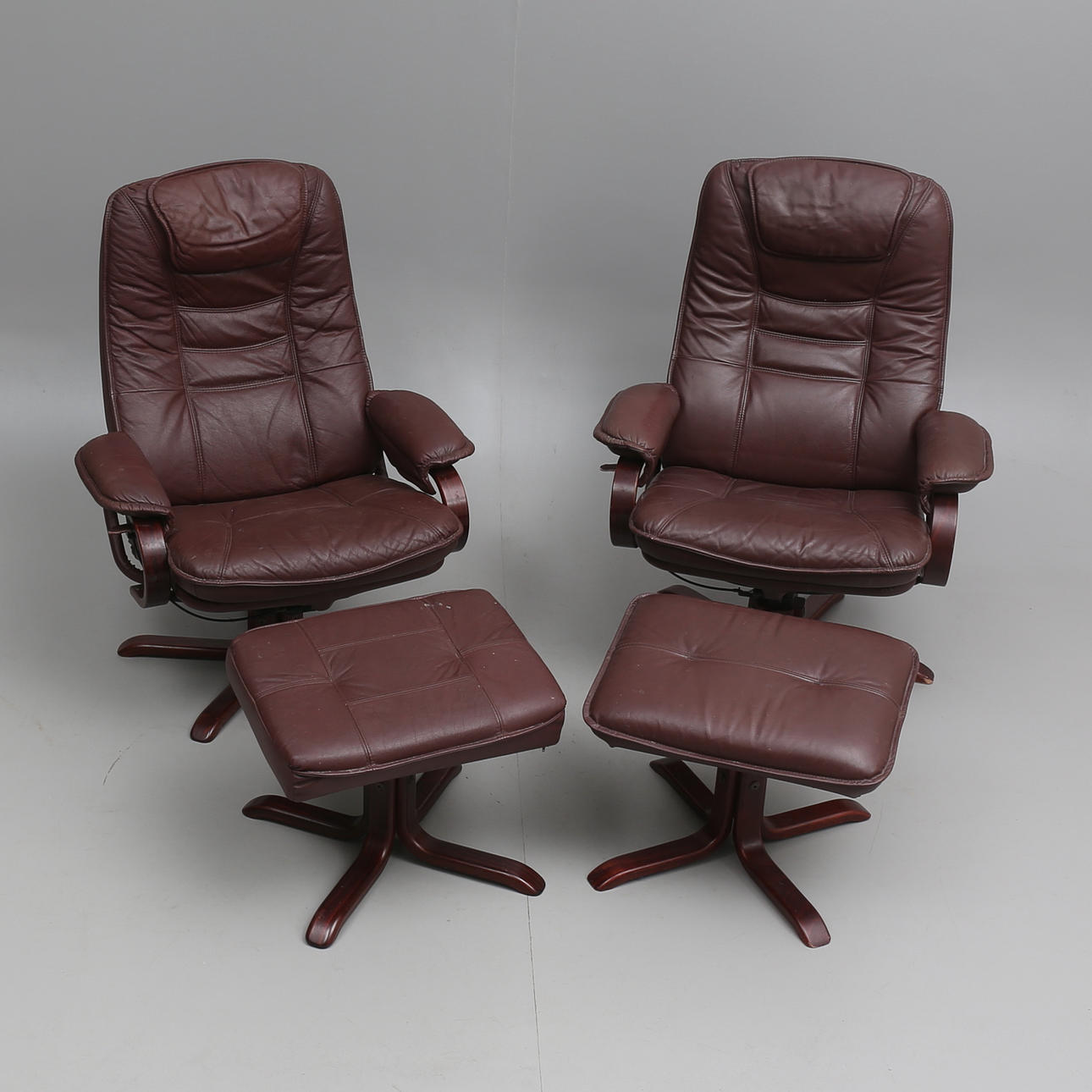 SNURRFÅTÖLJER, ett par med FOTPALLAR, 1900-talets andra hälft.