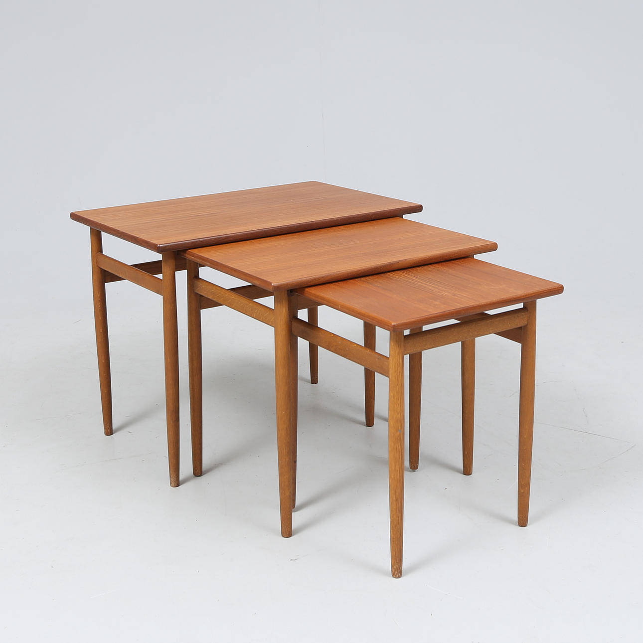 A set of three teak tables, mid 20th century.