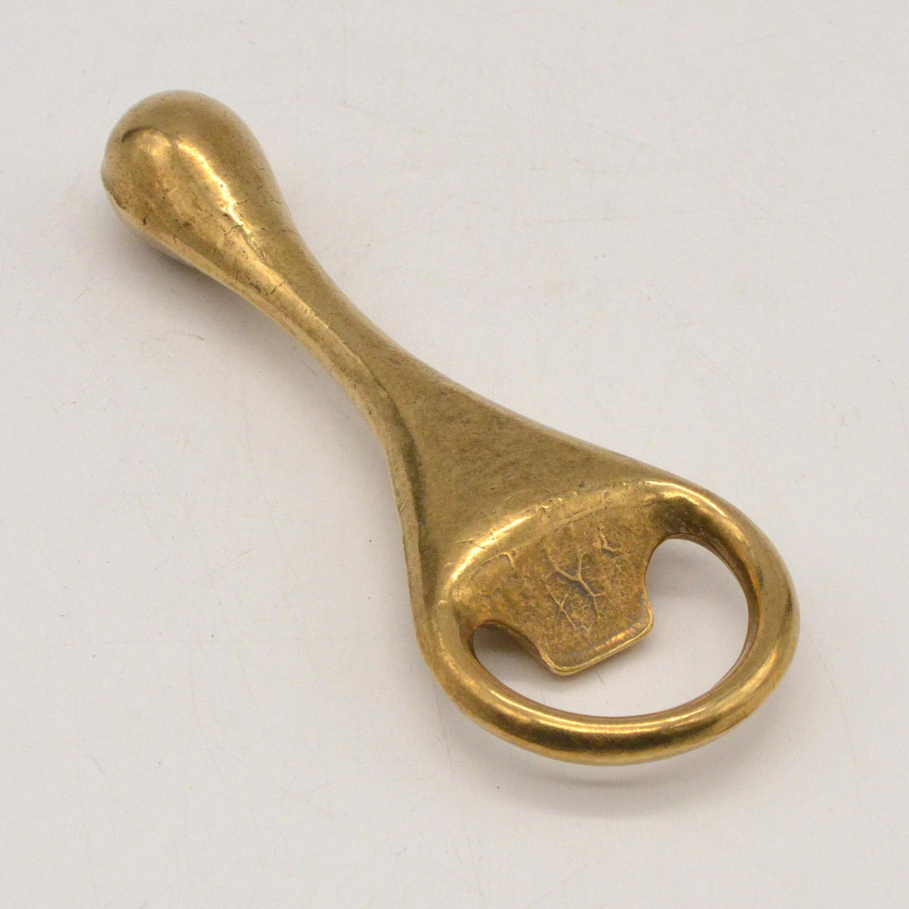 CARL AUBÖCK. FLASCHENÖFFNER, MESSING, UM 1950.