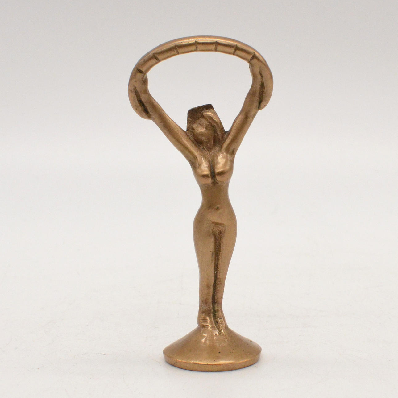 FLASCHENÖFFNER, DAMENAKT, MESSING, UM 1950.