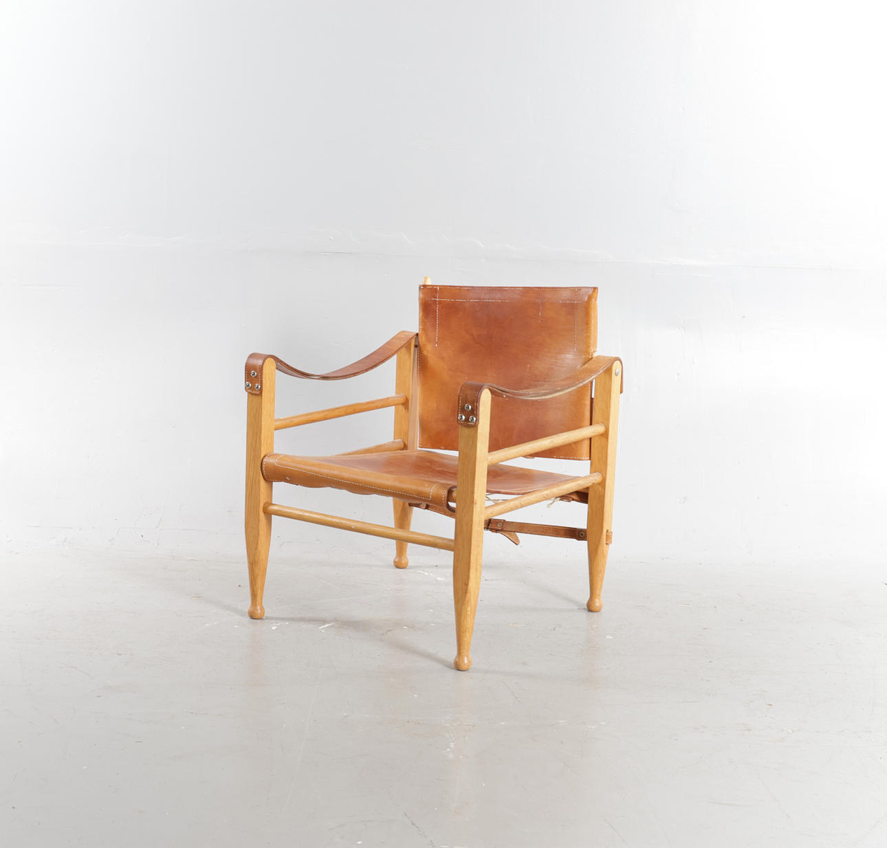 AAGE BRUUN. “Safari chair”, solid oak frame, stretched with patinated core leather. Manufactured at Aage Bruun & Søn, Denmark, second half of the 20th century.