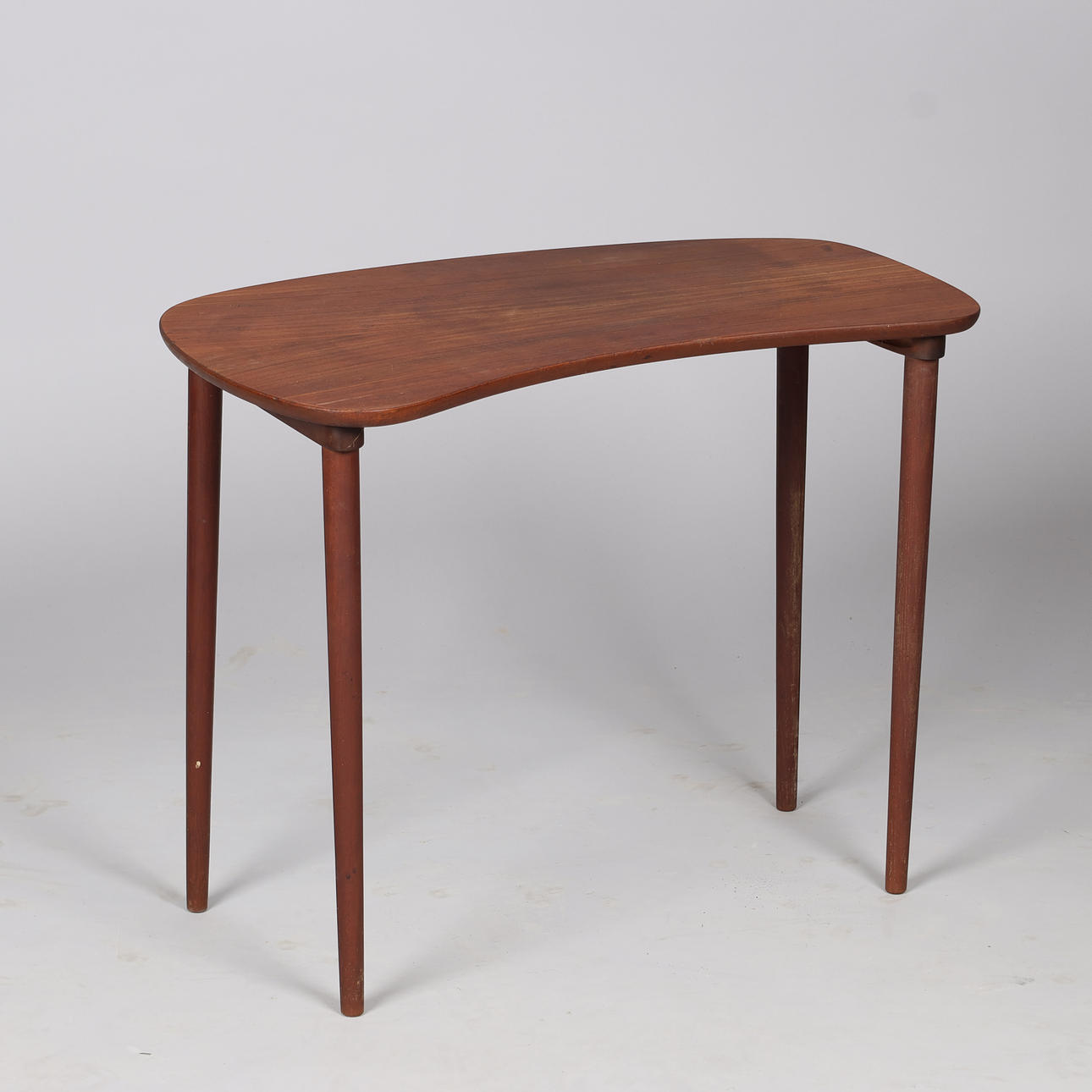Small teak side table on thin tapered legs.