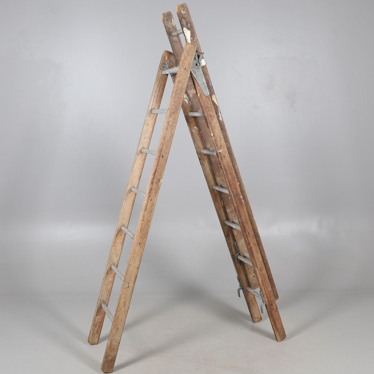 AN EXTENDING THREE SECTION WOODEN LADDER.