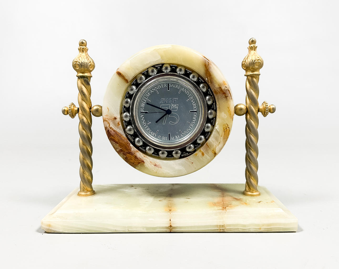 A 20th-century “SKF 75th Anniversary” table clock, brass, marble.