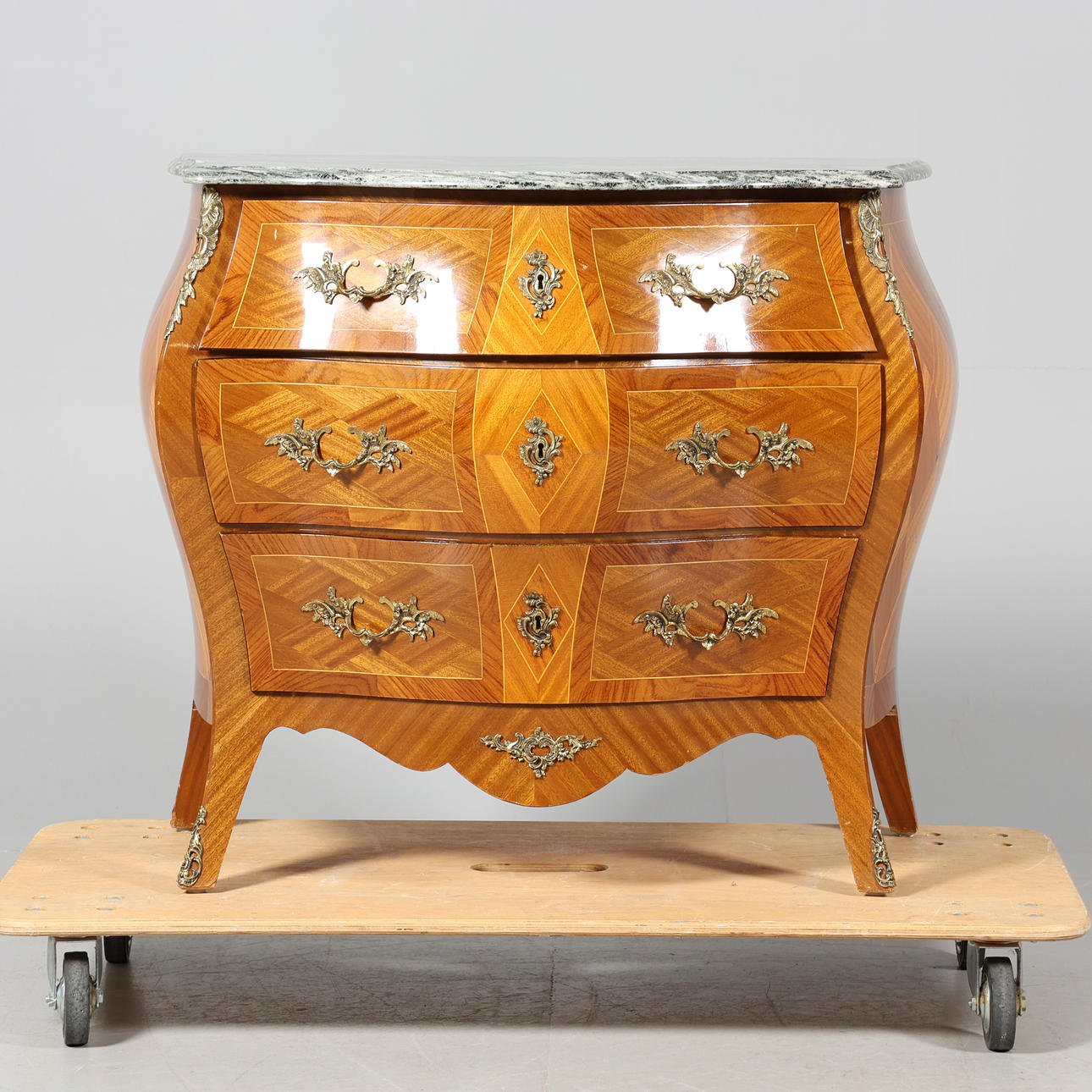 Còmoda de cajones con tapa de piedra, de estilo rococó.