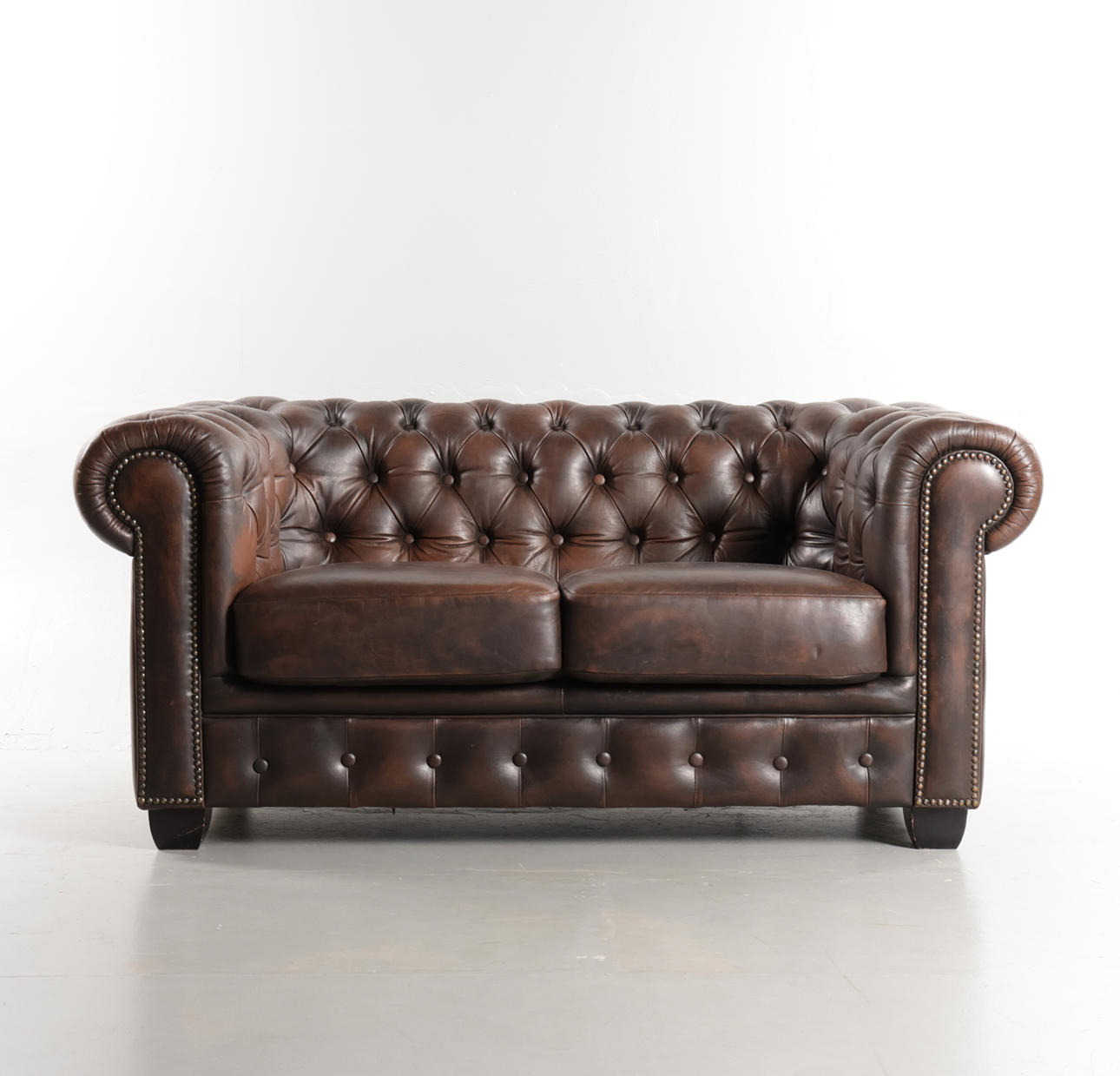 Two-seater sofa, deep-pocketed leather - Chesterfield style.