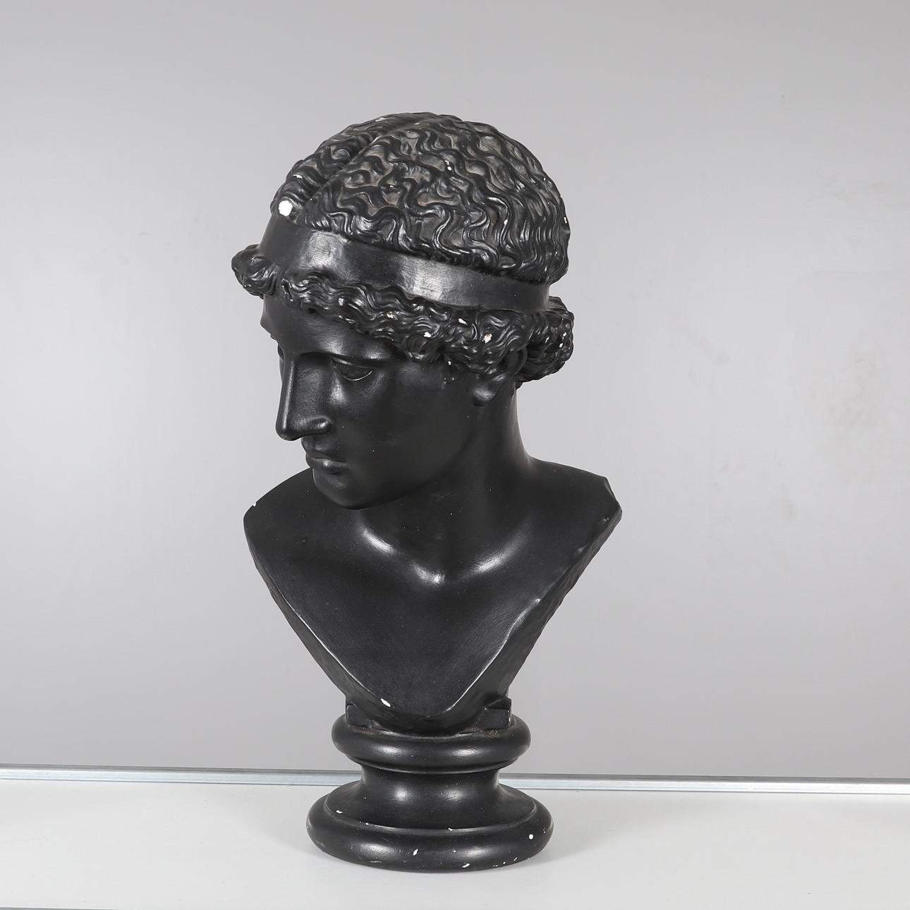 A BLACK PAINTED CLASSICAL PLASTER BUST.