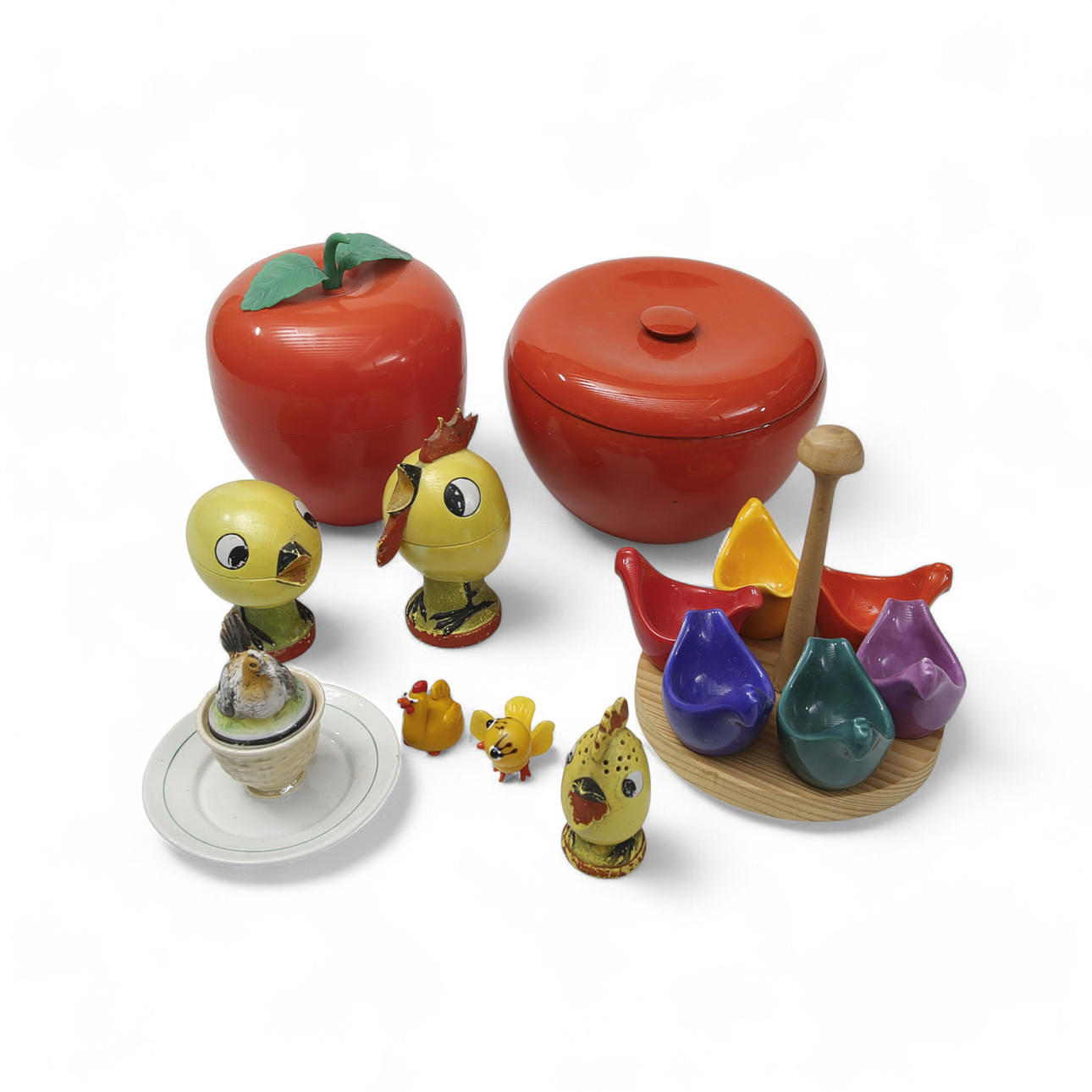 EIERBECHER AUF STÄNDER, Porzellan, polychrome und GRÖSSERE DOSEN/EISEIMER, Kunststoff, UND BEHÄLTER, SPRINKLER, MINIATUREN, OSTERDEKORATIONEN, 6 Stück, Porzellan, Hühnerform, gelb glasiert mit Kaltlackierung. Art Deco, 20. Jahrhundert.