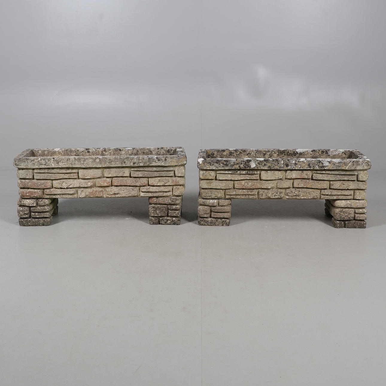 UN PAR DE MACETEROS RECTANGULARES DE PIEDRA SANDFORD.