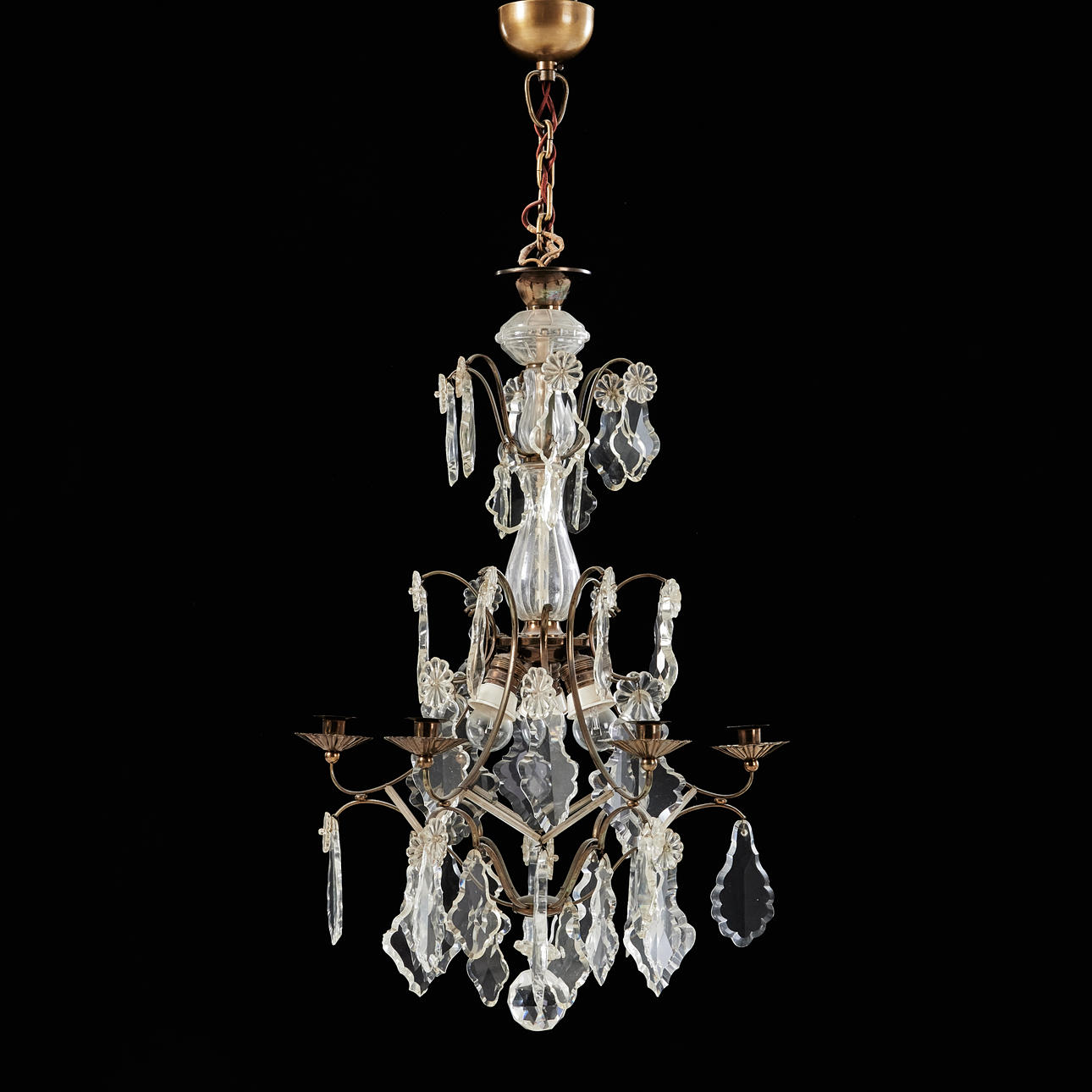 A rococo style chandelier, 1920s, hung with different cut prisms, including leaf-shaped flaps.