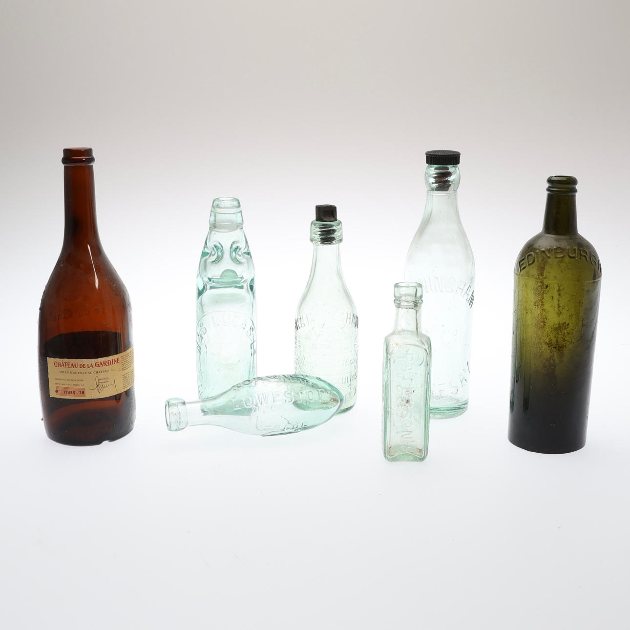 A COLLECTION OF GLASS BOTTLES.