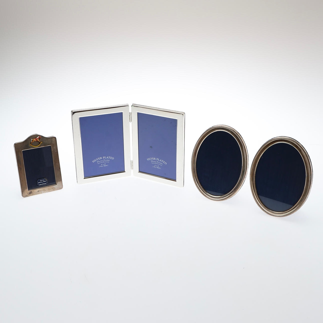 PAIR OF SILVER MOUNTED OVAL PHOTOGRAPH FRAMES, ANOTHER SILVER FRAME, AND A PLATED FRAME. (4).