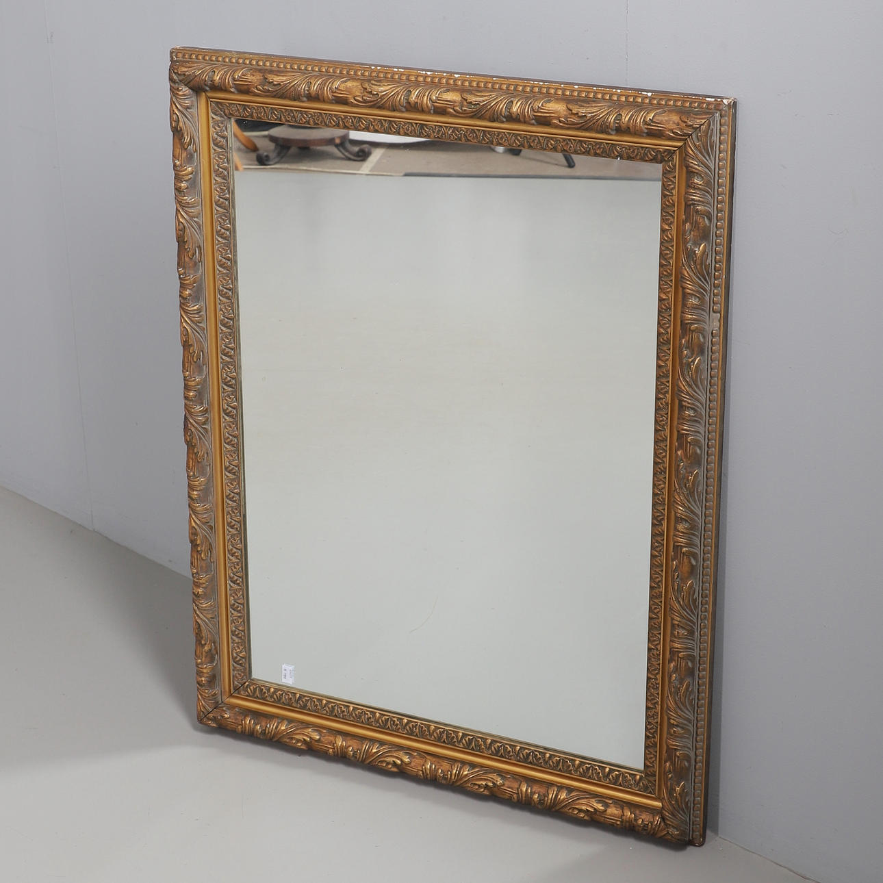 A RECTANGULAR GILT PLASTER FRAMED WALL MIRROR.