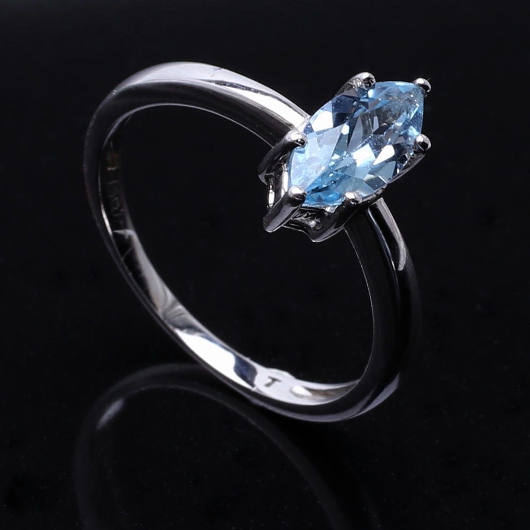 RING i 18 K vitguld med navetteslipad himmelsblå sten.