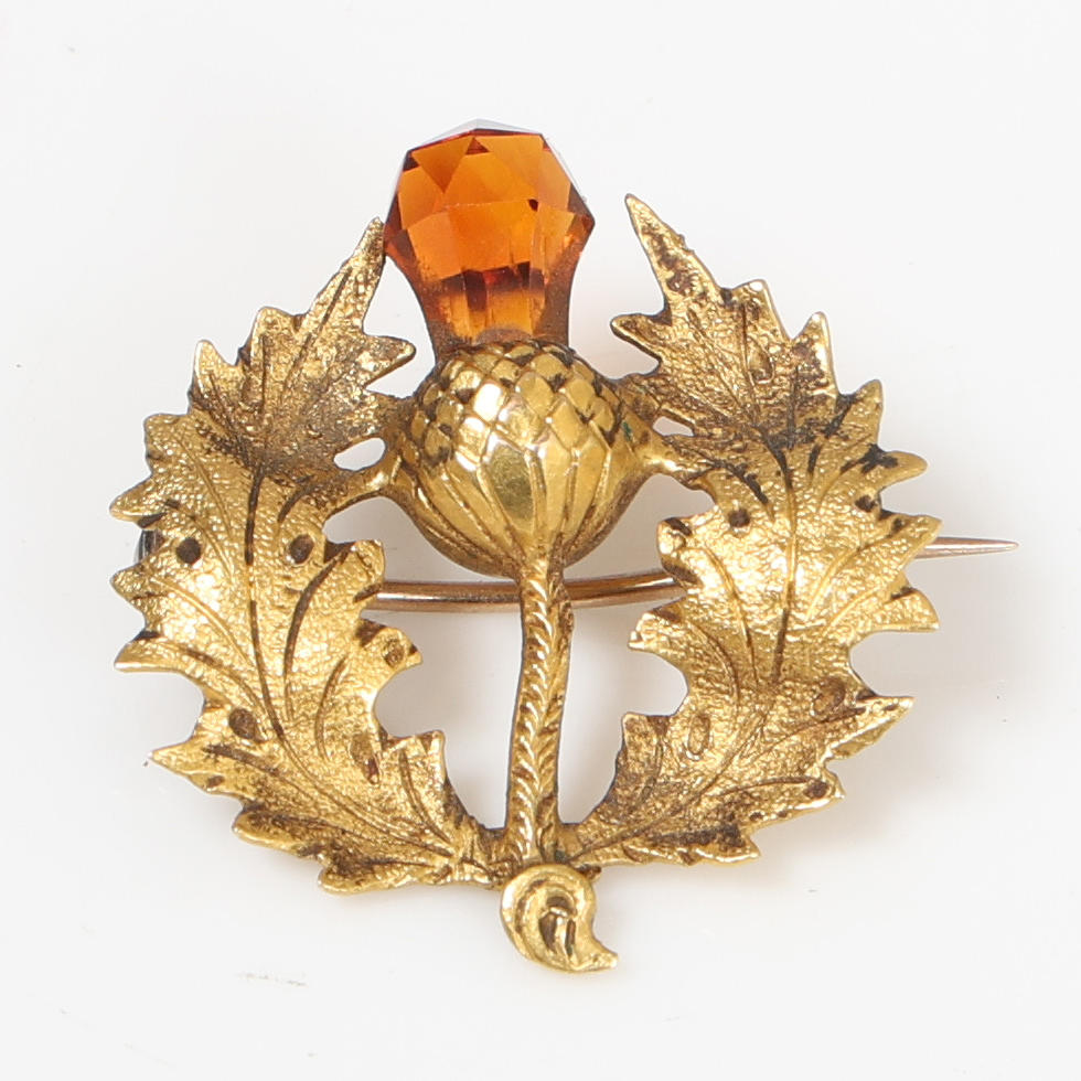 EINE BROSCHE AUS 15-KARÄTIGEM GOLD UND EINER STEINFIGURMDISTEL.