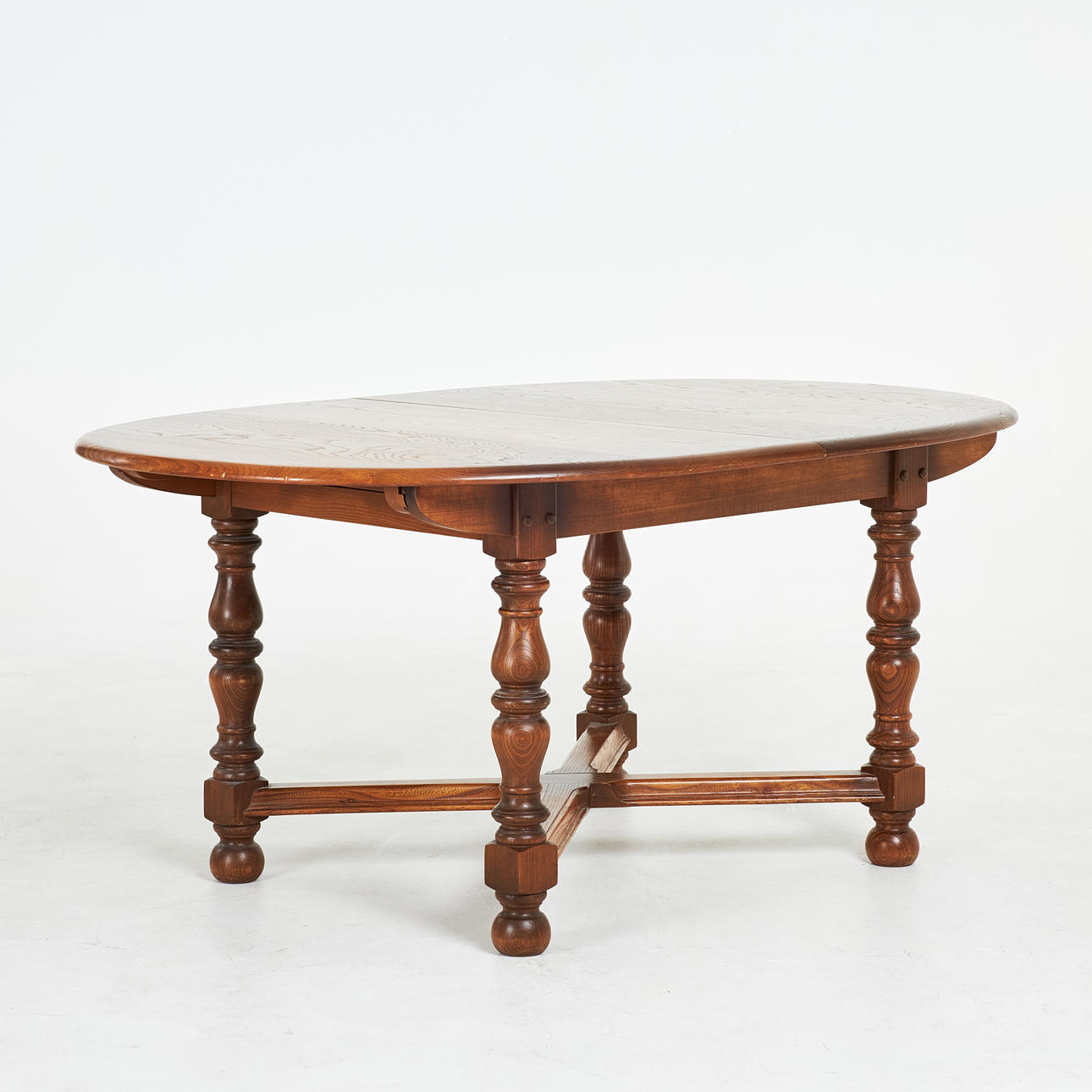 DINING TABLE, England, dark stained wood, labelled Ercol underneath, with insert top.