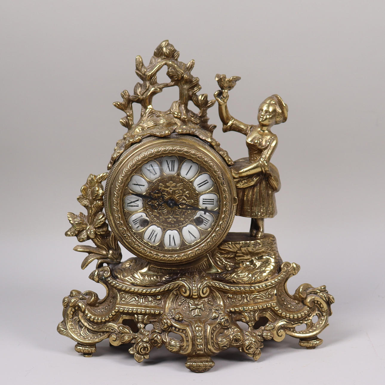 A Genfa rococo style metal table clock with figural decor, Germany, 20th century.