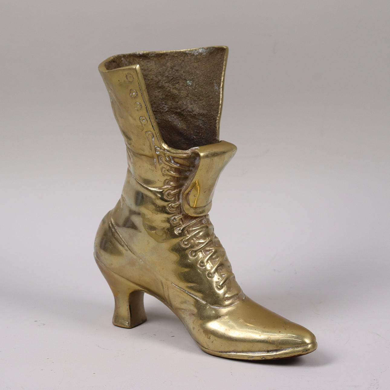 VAS, mässing i form af damstövel.