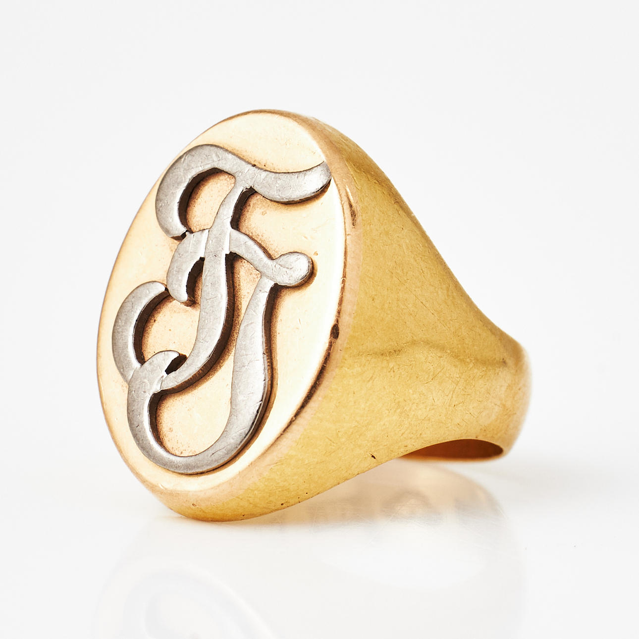 A SIGNET RING, 23k red and white gold, Västervik 1900, applied monogram TJ.