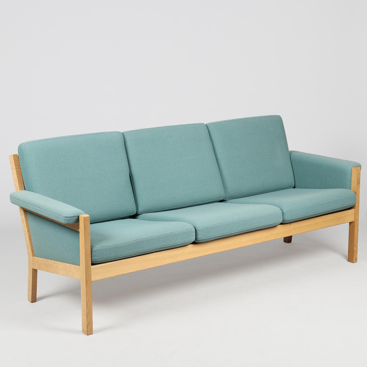 HANS J WEGNER. “GE40" three-seater sofa in solid oak and green wool, Getama, Denmark.