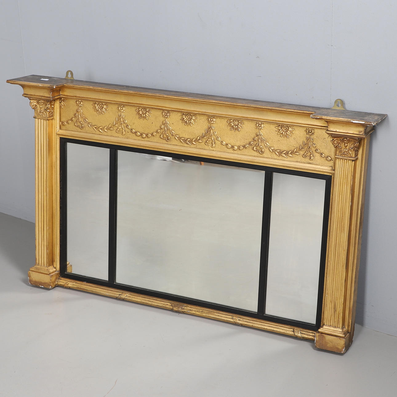 A REGENCY STYLE GILT FRAMED SECTIONAL WALL MIRROR.