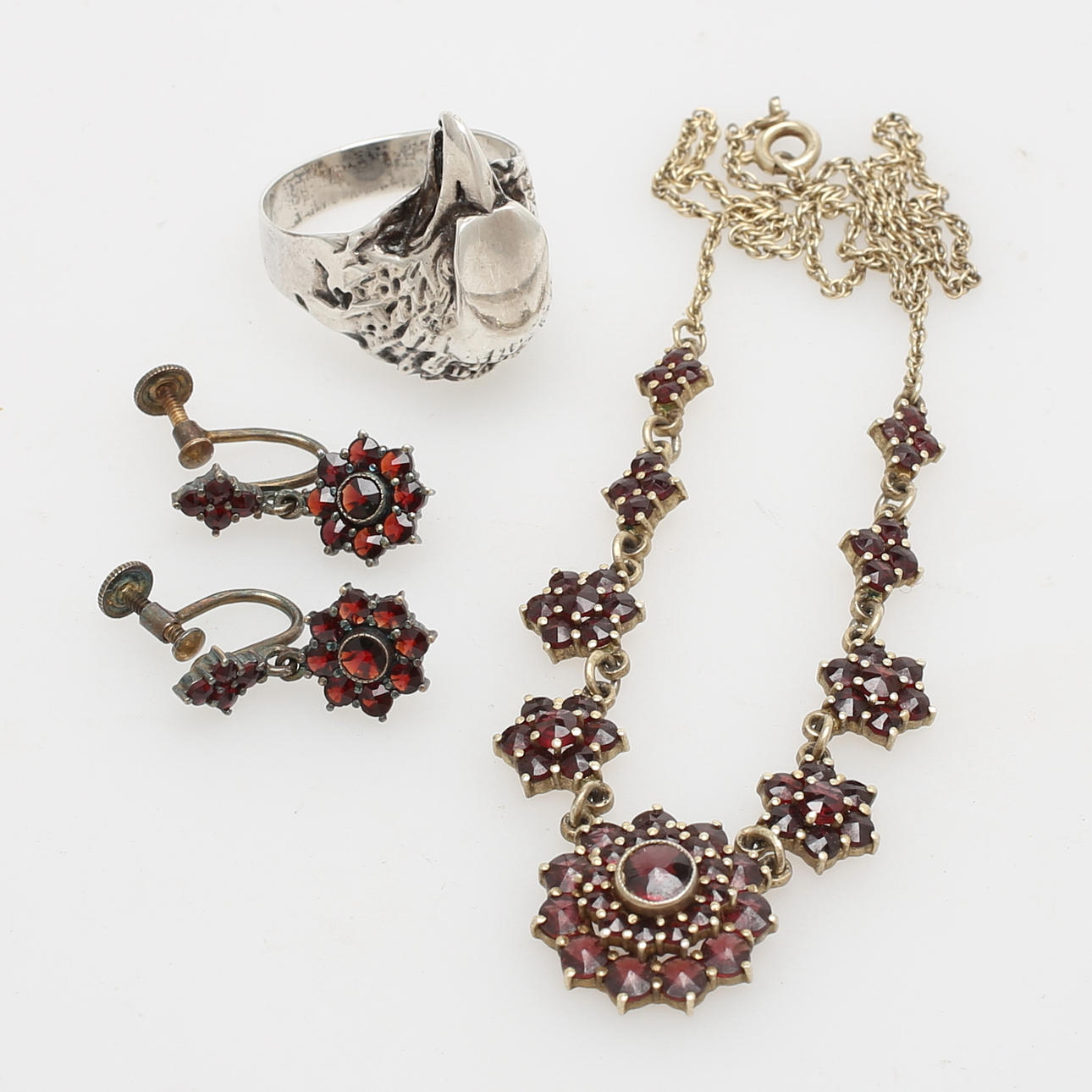 HALSBAND och ÖRHÄNGEN, ett par, granater/mässing, samt RING, silver.