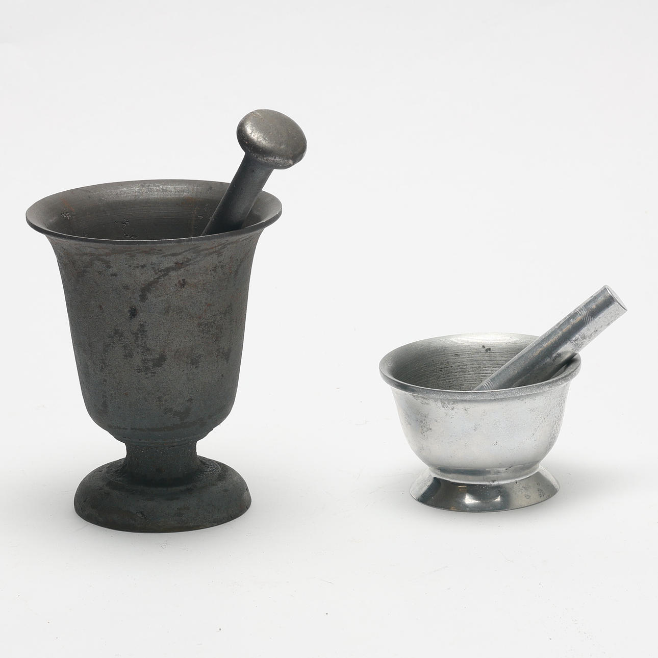 MORTARS. 2 pcs, 1 cast iron, 1 tin, both with associated mortars.