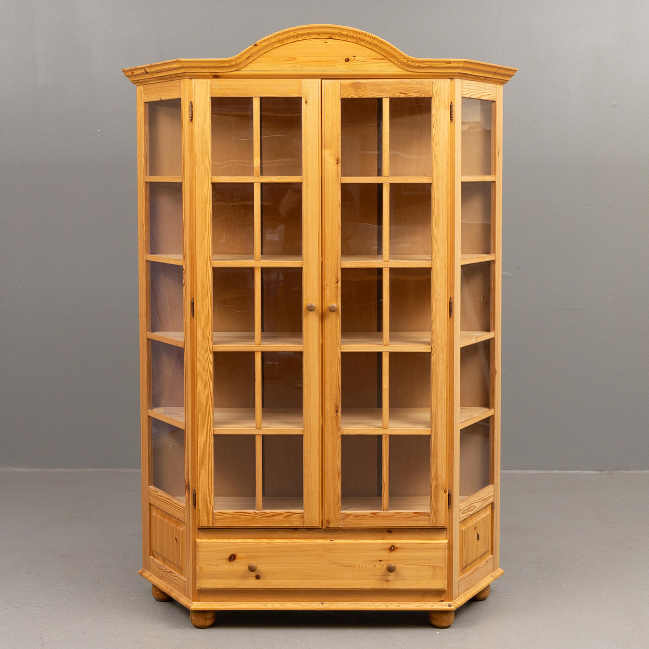 A pine wood display cabinet.