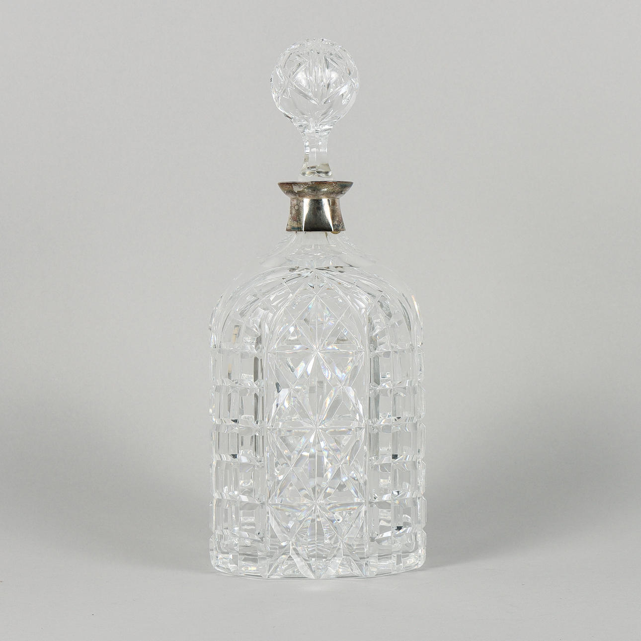 A decanter, cut crystal with nickel silver collar.