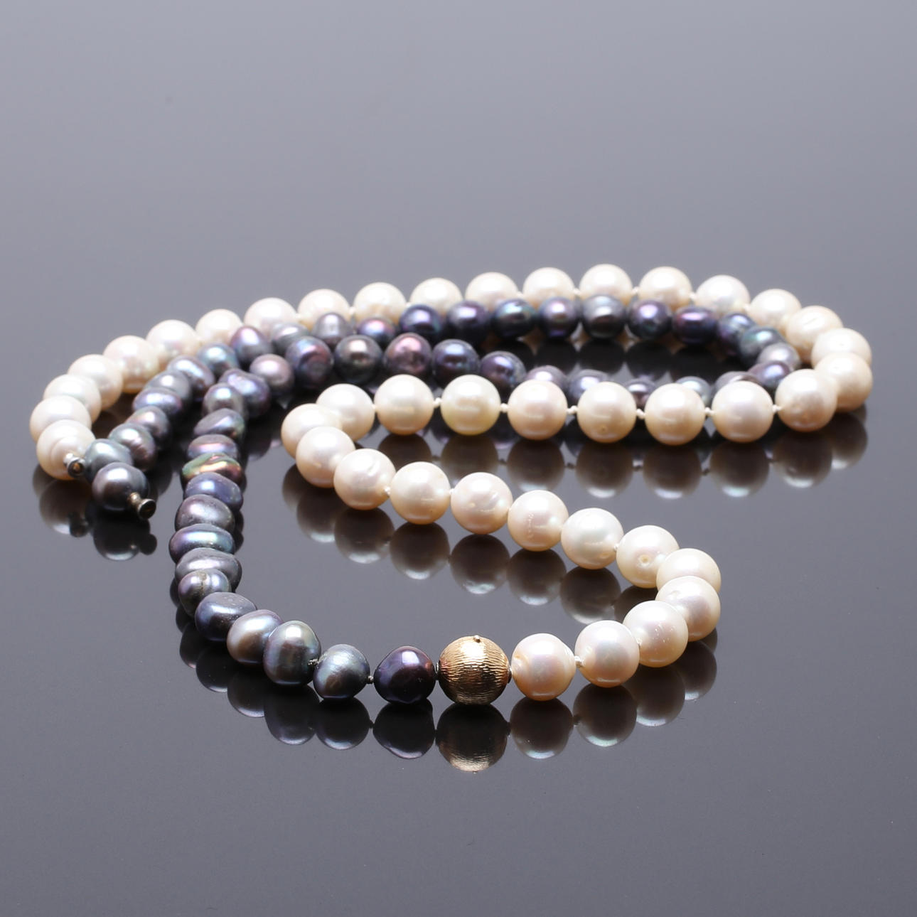 PÄRLCOLLIER av svarta och vita barocka pärlor, 10-11mm med spänne i 18 K guld.