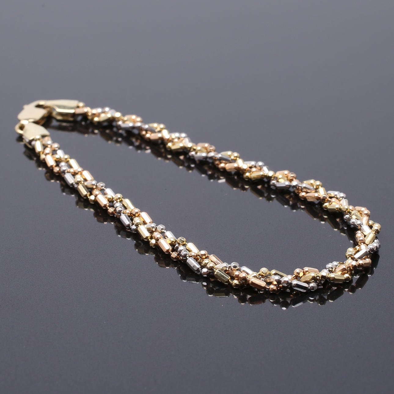 ARMLÄNK i 18 K trefärgat guld, vikt 6,88 g.