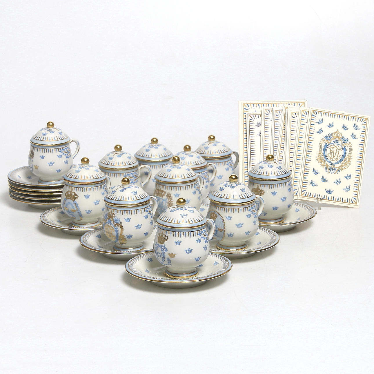 CRÉMEKOPPAR med FAT, 22 delar, fältspatsporslin, Rörstrands samlarserie med Kungliga namnschiffer, 1900-tal.