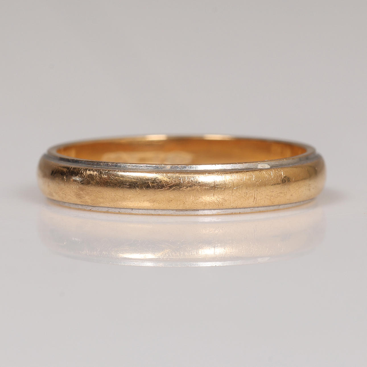 An 18 carat gold two tone wedding ring