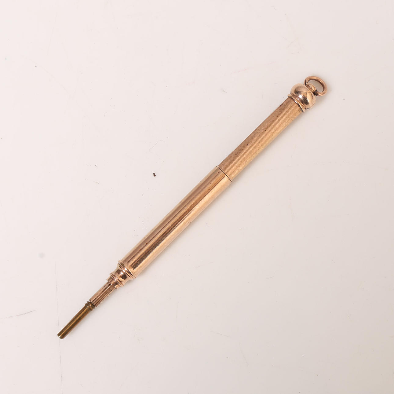 UN LÁPIZ PROPULSOR DE METAL AMARILLO.