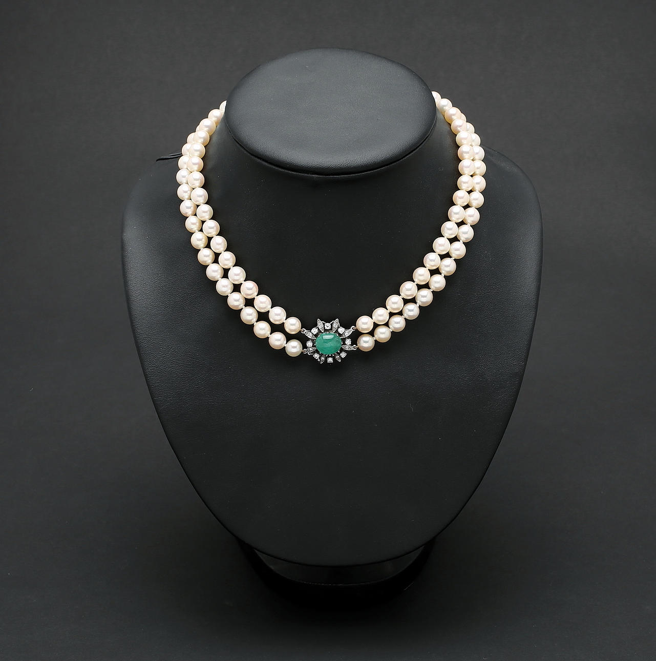 PÄRLCOLLIER, 97 odlade saltvattenpärlor, lås i 18K vitguld med ca 0,60 ct briljanter samt större cabochonslipad smaragd, Hovjuvelerare CF Carlman, Stockholm.