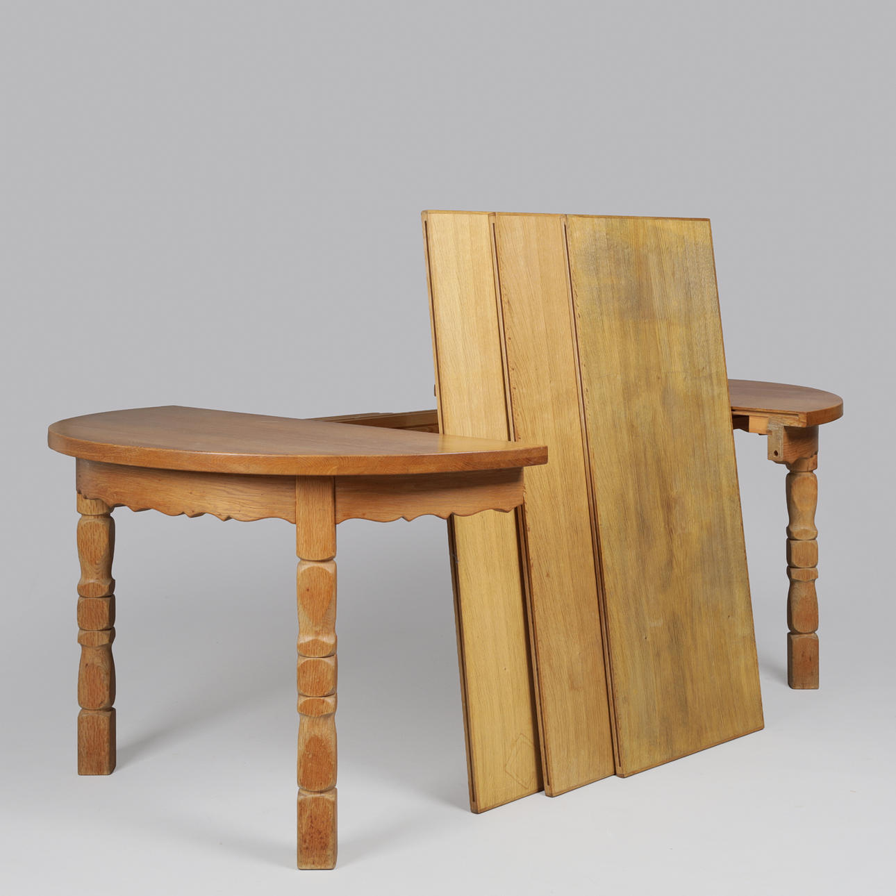 Circular dining table made of solid oak with pull-out and additional plates, Kjærnulf style, Danish furniture manufacturer, Denmark, second half of the 20th century (1+3).