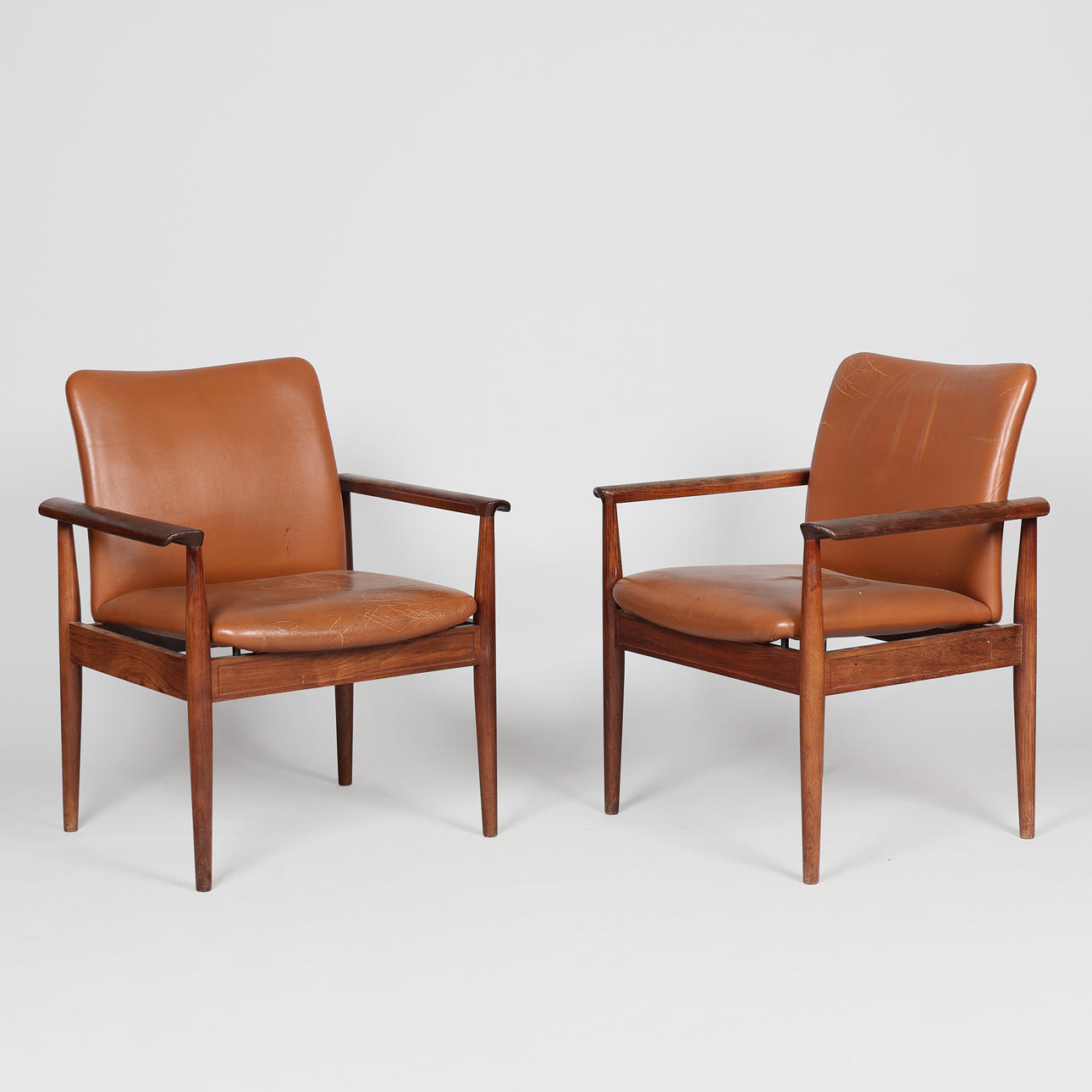 FINN JUHL. A pair of “Diplomat” armchairs, rosewood frame, seat and ...