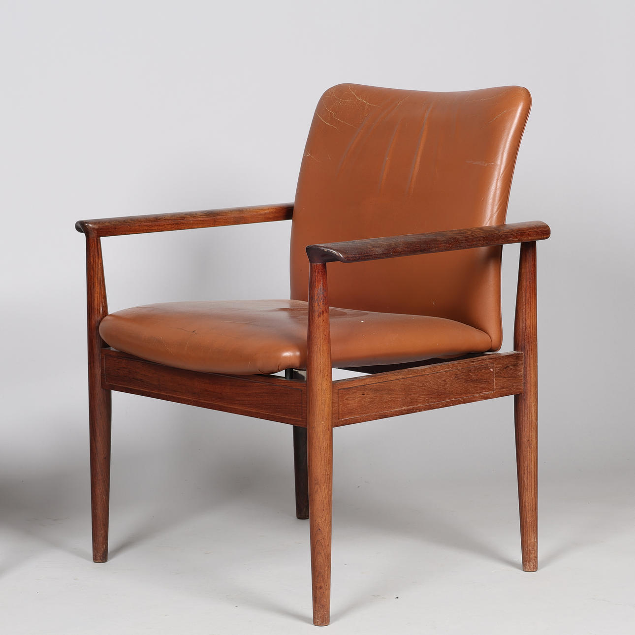 FINN JUHL. A pair of “Diplomat” armchairs, rosewood frame, seat and ...
