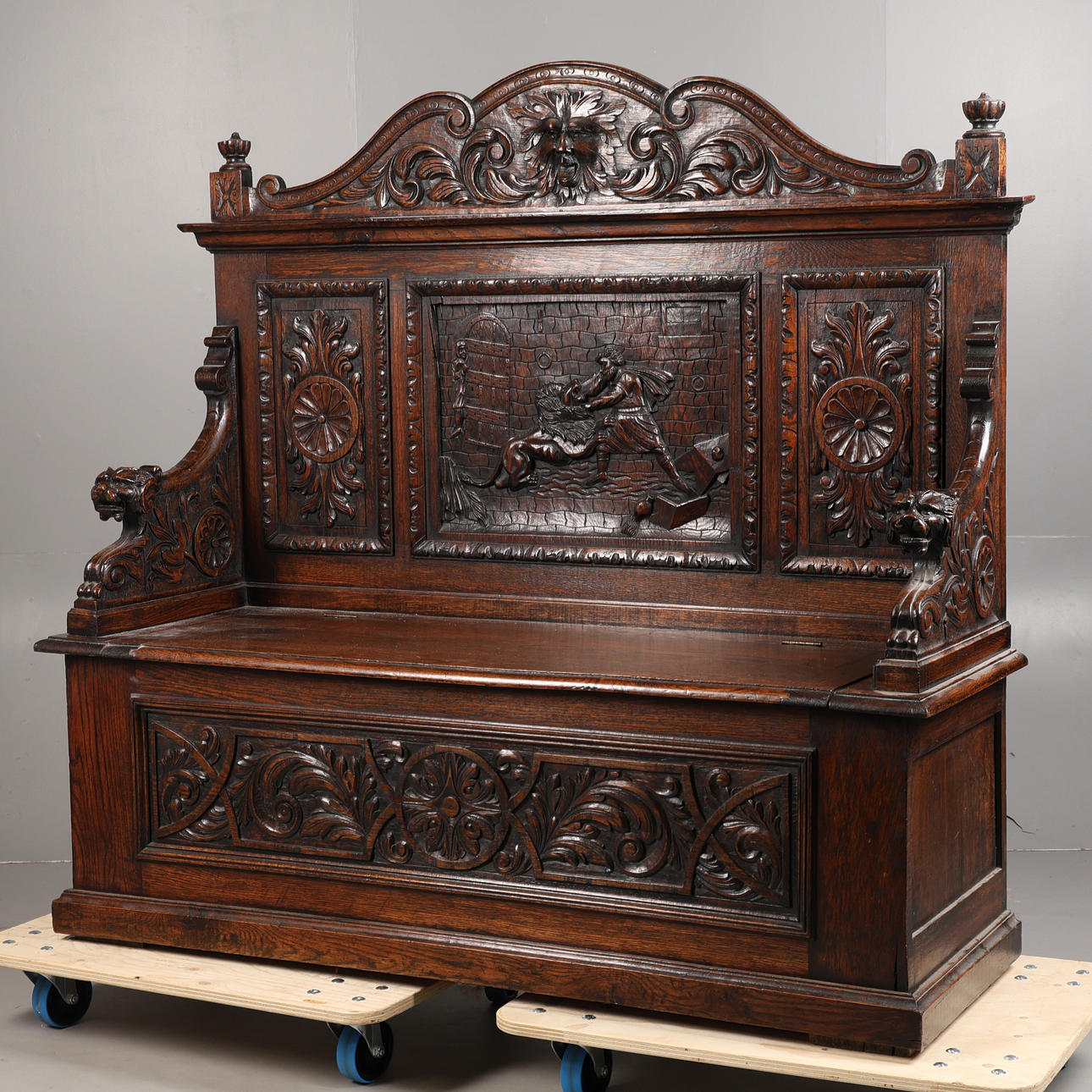 A VICTORIAN CARVED OAK SETTLE.
