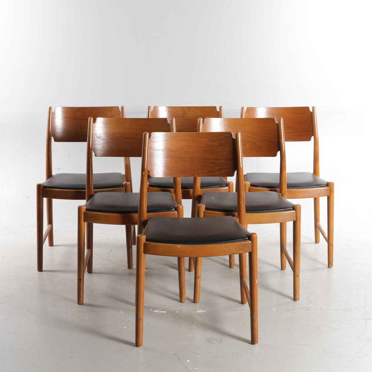DANSK MØBELDESIGN. Set on six chairs with teak cups, frames of stained beech with visible joints at the rear, seats upholstered in black skai. Manufactured at SAX, Denmark, 1950-60s (6). Furniture
