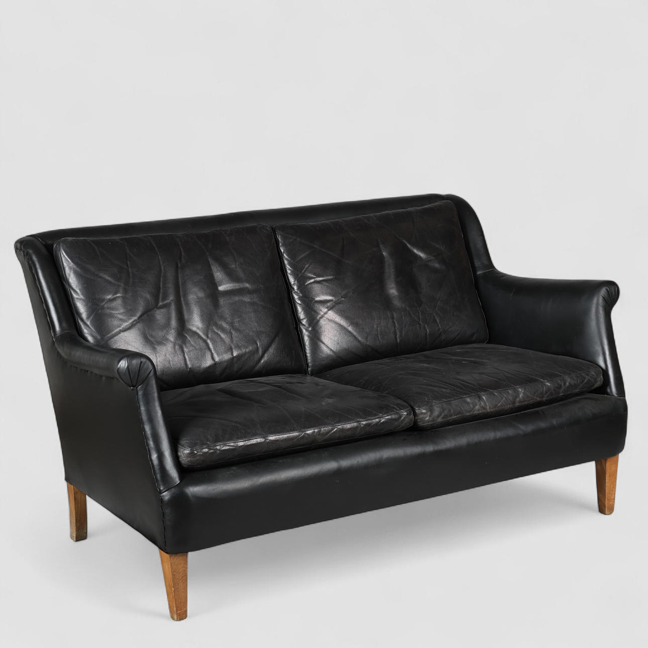 Dansk Design. To personers sofa, sort læder og bøg. 1900 tallet midte ...