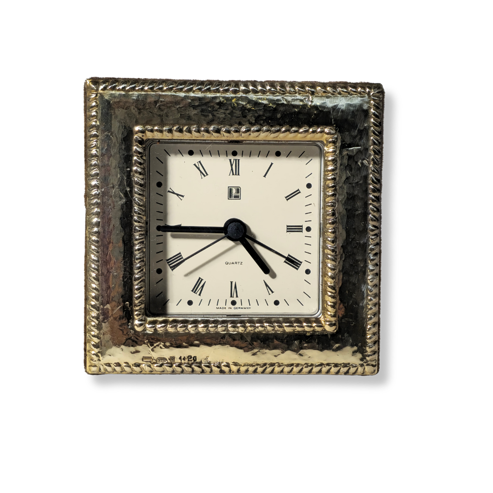 DESKTOP ALARM CLOCK WITH HAMMERED SILVER FRAME AND BRAIDED BORDER.