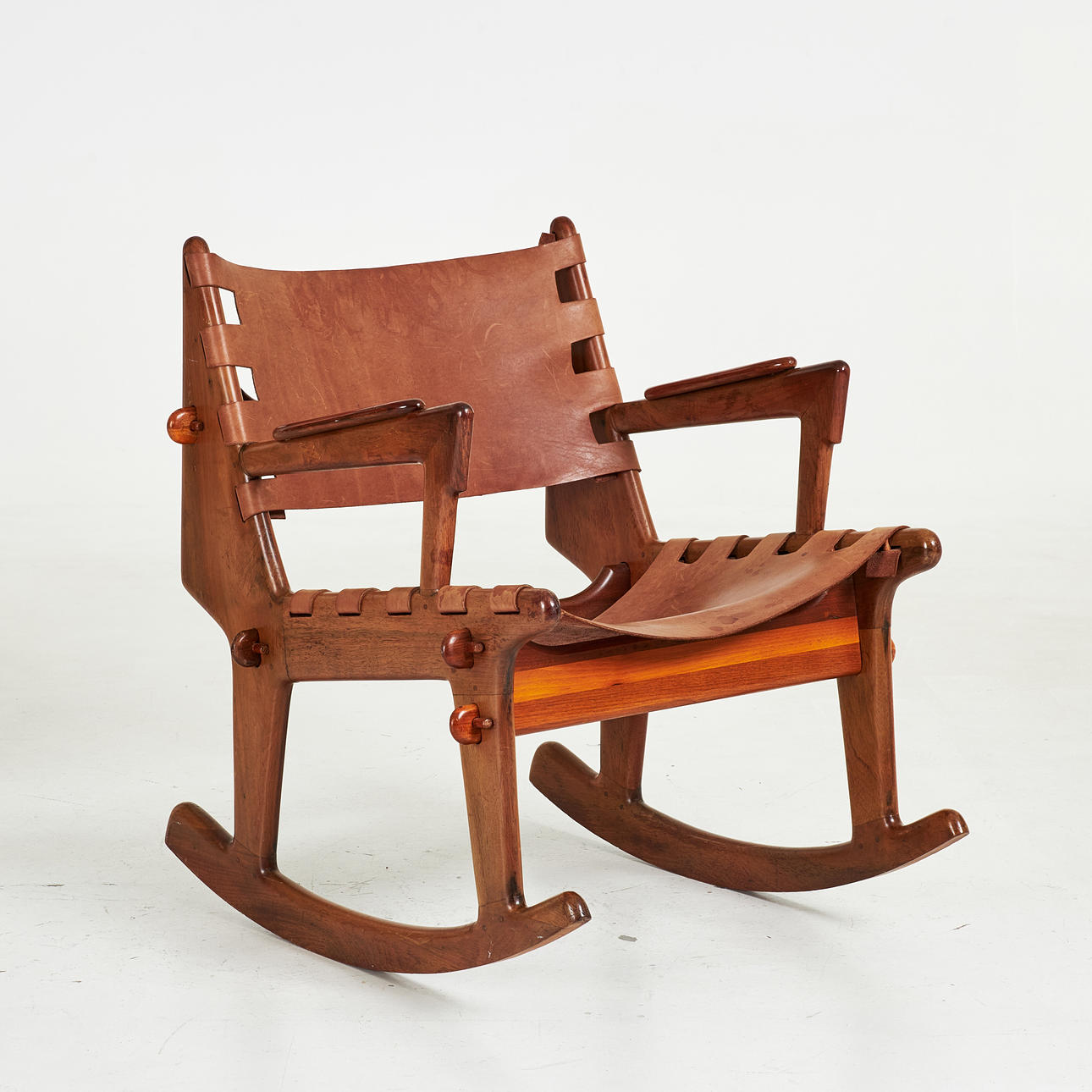 ANGEL PAZMINO. A mid 20th century rocking chair, walnut, upholstered in ...