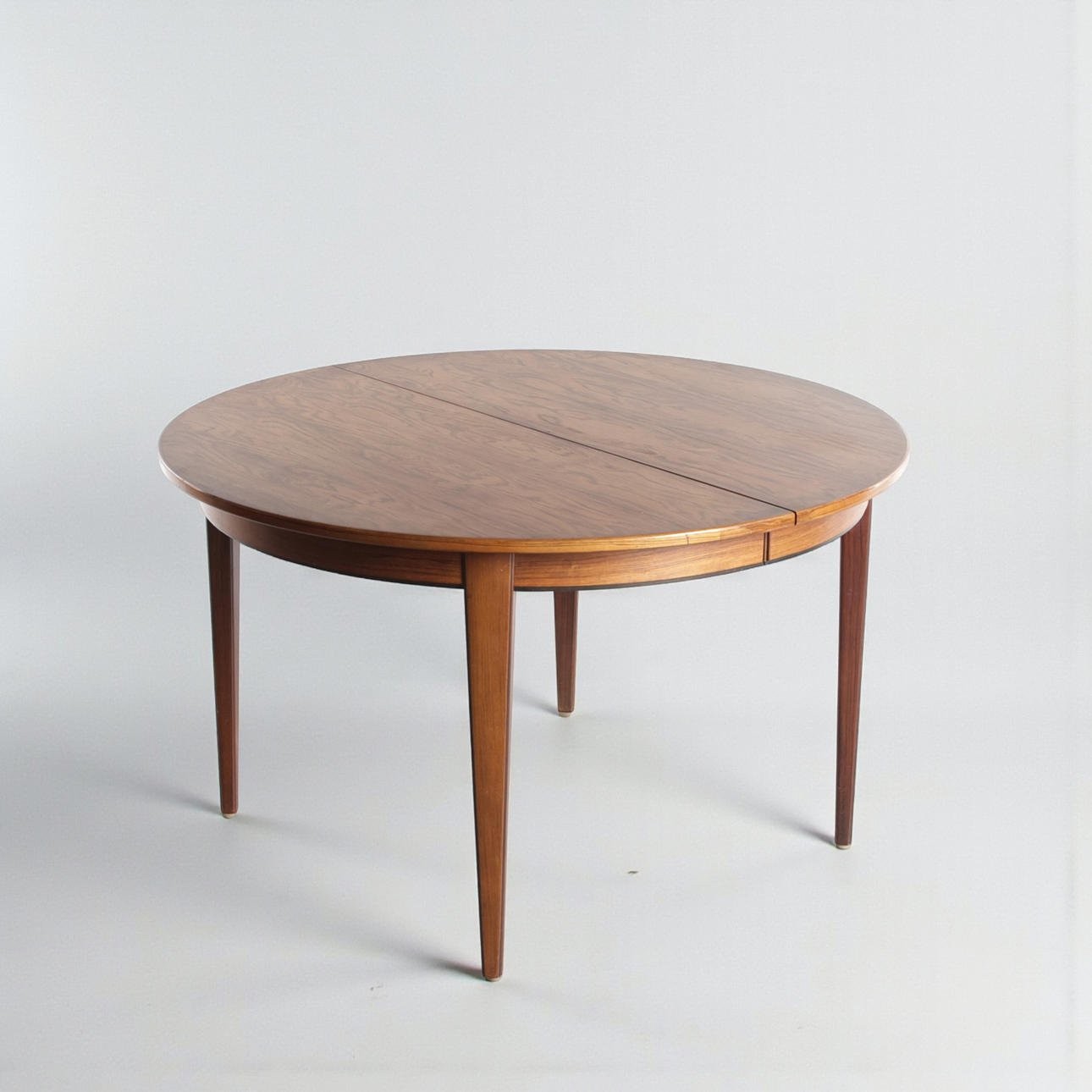GUNNI OMANN. Circular rosewood dining table with pull-out, three additional plates included. Manufactured and marked at Omann Jun's Møbelfabrik, model '55'. (1+3).
