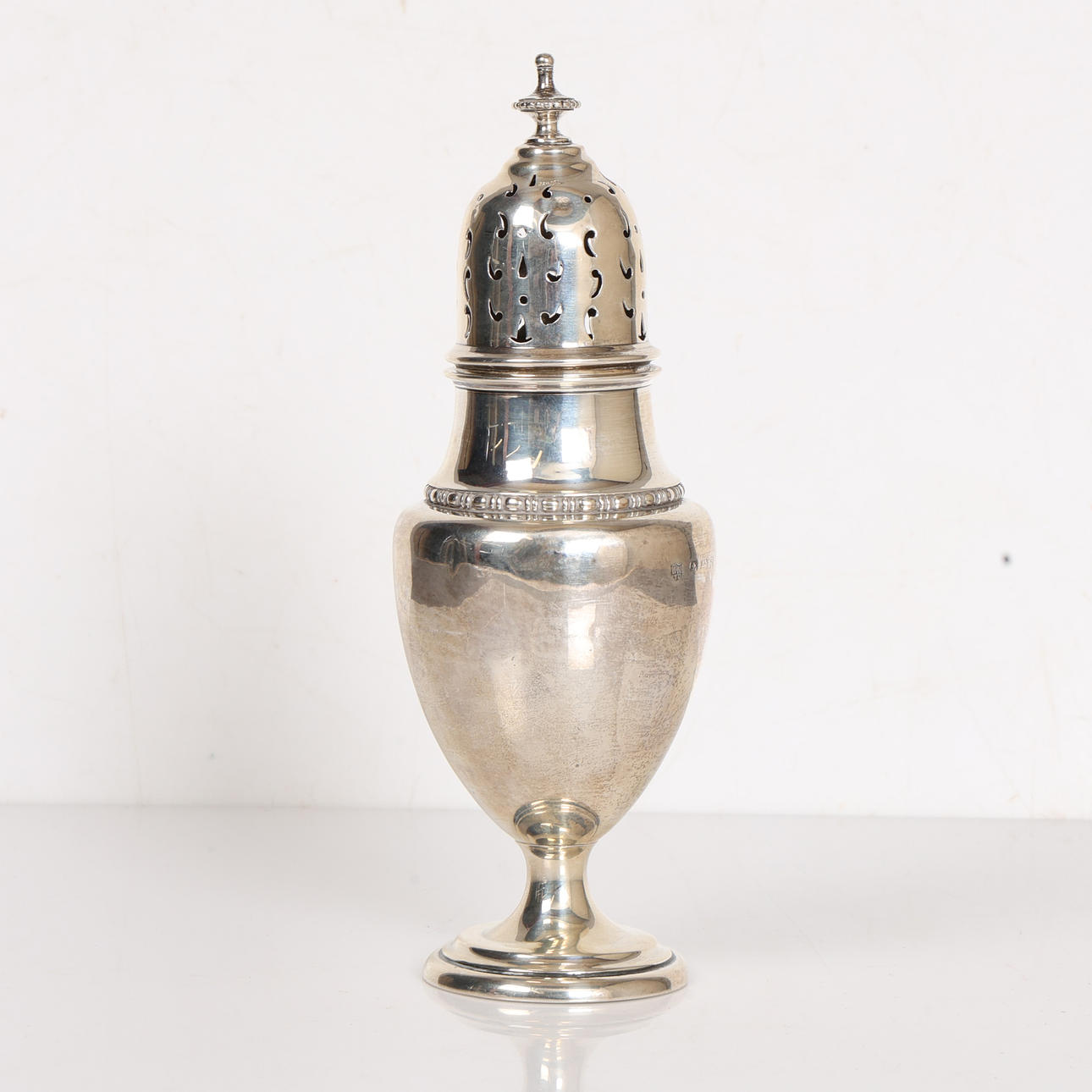 A GEORGE V SILVER SUGAR CASTER.