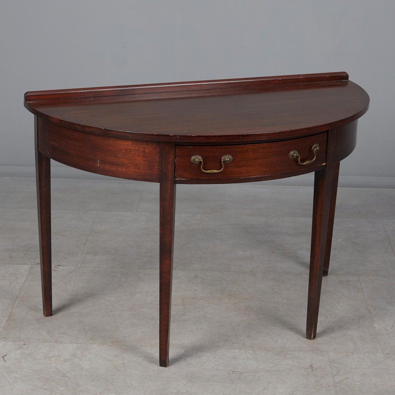 Console/semicircular table, recessed drawer, brass fittings. Furniture ...
