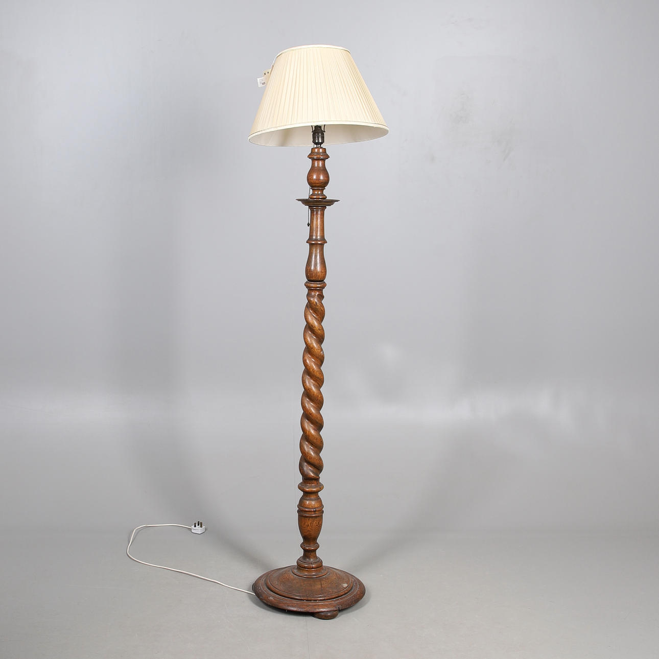 AN OAK BARLEY TWIST STANDARD LAMP.