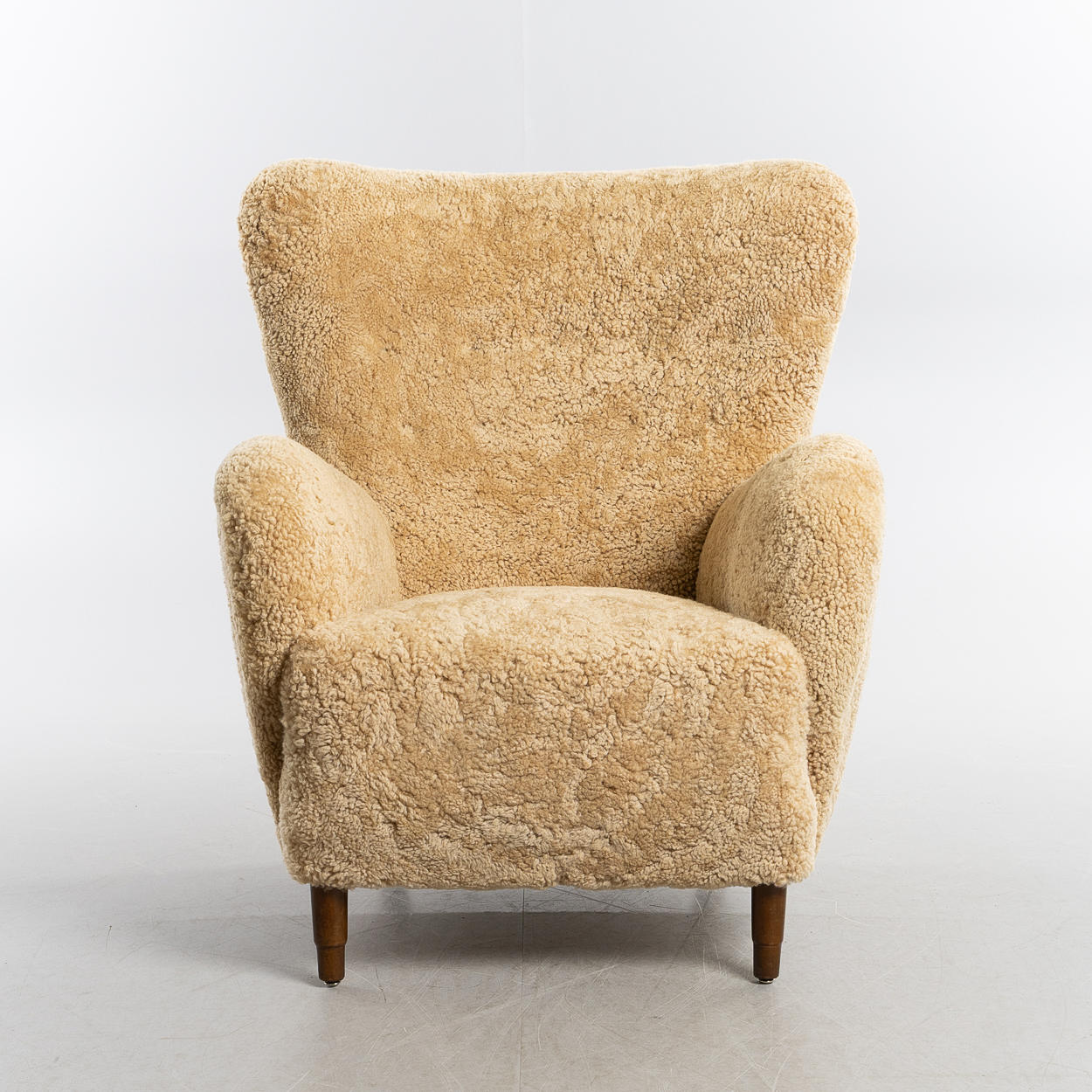 Ein Sessel, dänisch modern, 1940er, bezogen mit Lammfell Honey.